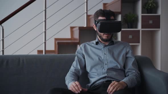 Man Using Virtual Reality Helmet or 3d Glasses and Relaxing at h