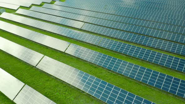 Flight Along Solar Panel on the Green Field. Solar Power Station for Production of Green Energy alt