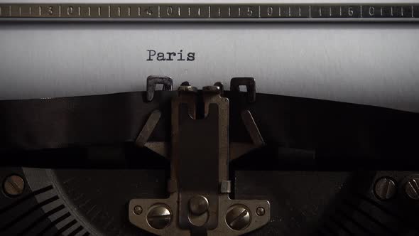 Typing city name Paris on an old typewriter. Close up. alt
