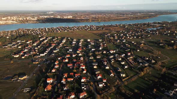 Aerial Overview of Many Small Modern Houses in Village Near River alt