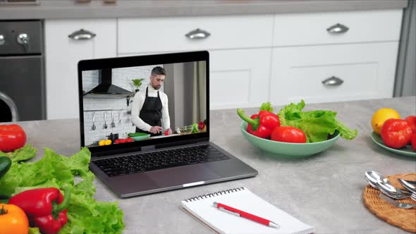 Laptop Computer with Man Food Blogger Tells Teaches Students Slices Tomato alt