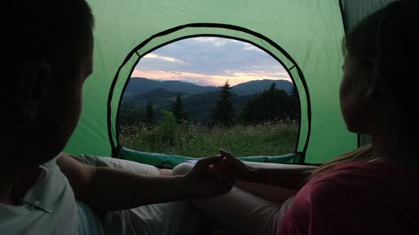 A Loving Couple is Resting in the Mountains They are Sitting in a Tent and Talking alt