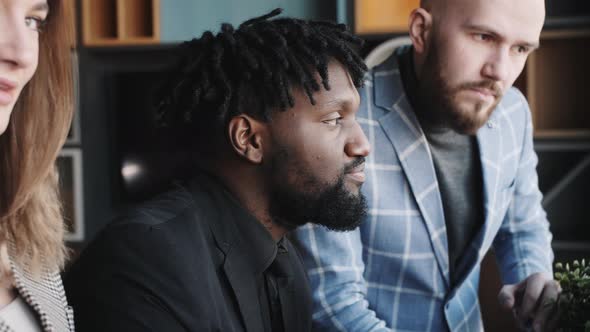 a Team of Young Developers are Discussing the Project at the Laptop alt