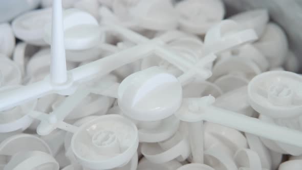 A Large Number of Small White Plastic Parts in the Factory