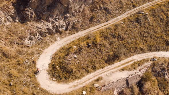 Man Ride Bicycle on the Mountain Road Shot By Drone alt