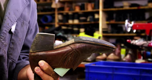 Cobbler hammering on shoe sole alt