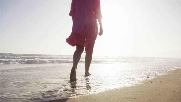 Pretty Woman in Pink Flattering Dress Walks at Seaside Surf Splashes of Water alt