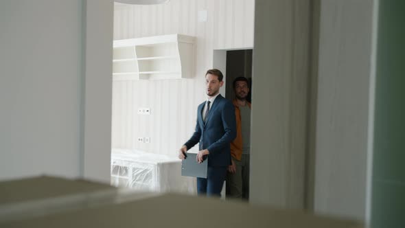 Realtor and Customers Entering Beautiful New House Talking Looking Around alt