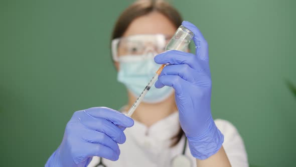 The Doctor Fills the Syringe With the Vaccine in Preparation for the Injection alt