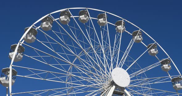 Ferris wheel in action againts a blue sky. alt