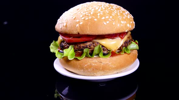 Appetizing burger on a black background. Delicious fast food.