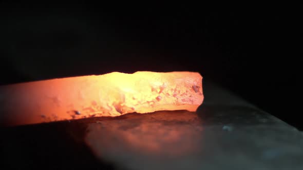 Slow motion of red hot shards bouncing while hammering. alt