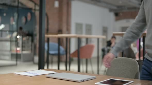 Young Man Opening Laptop While Sitting in Office alt
