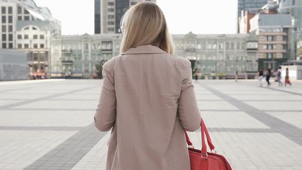 Business Woman Walks Across the Square in a Big City alt