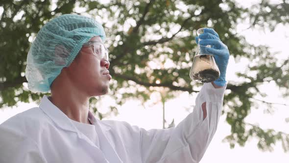 Scientist in protective suits and mask check contaminants in factory wastewater