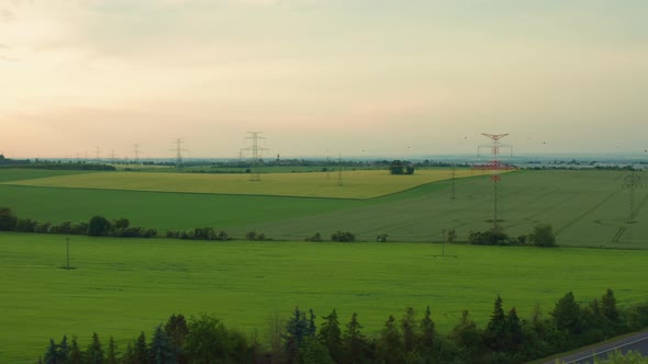 Power Transmission Lines in Field at Sunset Aerial View alt