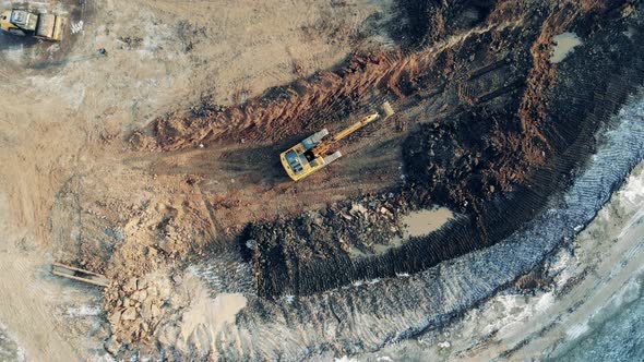 Large Quarry Site with an Excavating Vehicle in a Top View. Heavy Industrial Equipment Working. alt