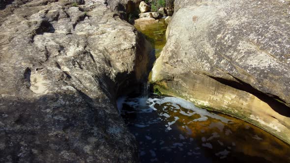 Water erodes a course through the granite rocks at Giant's Cauldron near Alicante, Spain - following alt