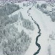 Drone following river and revealing beautiful Swiss town in snow covered landscape - VideoHive Item for Sale