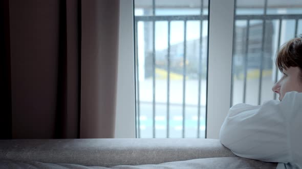 Sad Woman at Home Looking Out the Window at People Passing By Cinematic Shot alt