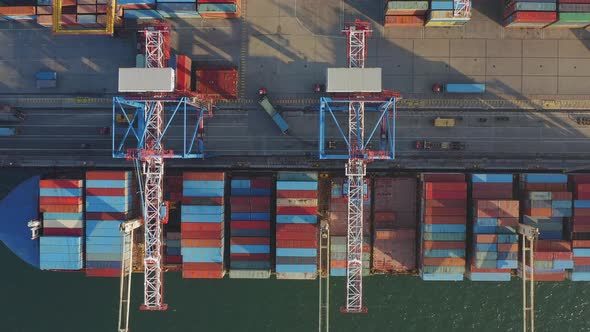 Loading and Unloading a Container Ship in the Port at the Pier alt