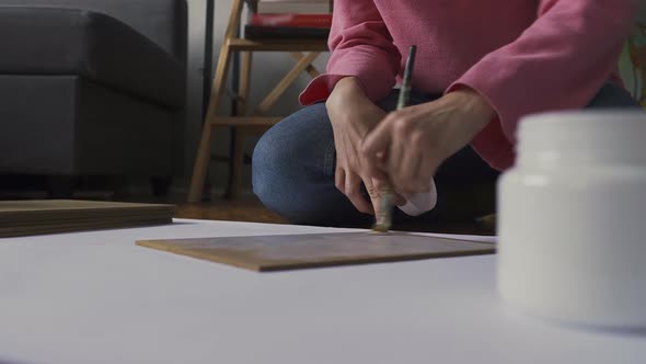 An Artist Primes Canvas with White Paint on Paper at a Drawing School
