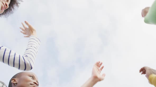 Diverse male and female business colleagues stacking hand and motivating in office alt