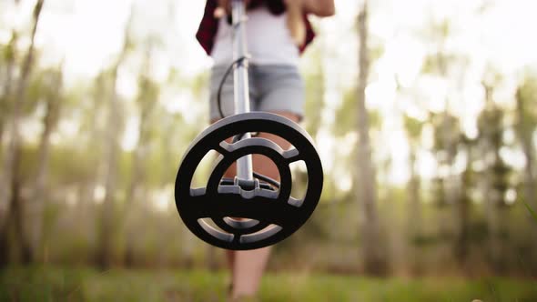 Low Angle View of the Woman Using Metal Detector. Selective Soft Focus alt