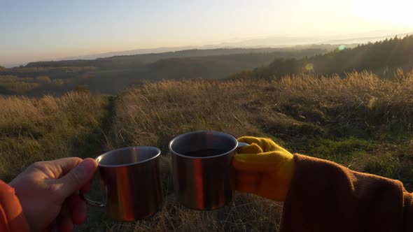 Couple drink tea in mugs in mountains