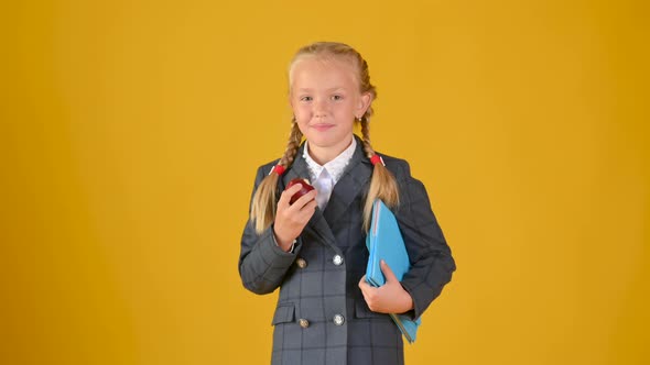 Portrait of a teenage girl schoolgirl in a school uniform with books in her hands alt