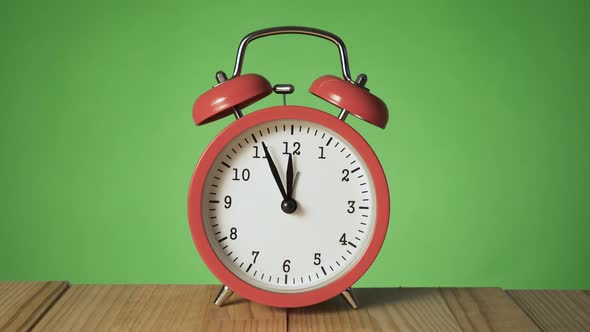 Vintage Red Alarm Clock on Natural Wooden Table Ringing at 12 O'clock