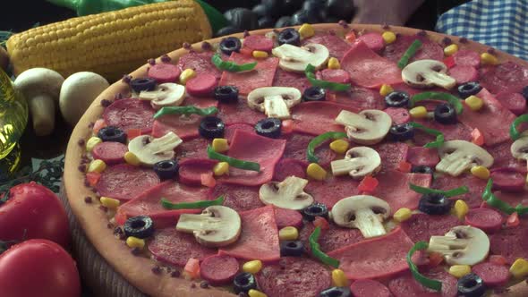 A cooked pizza with various of toppings on a decorated table