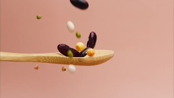 Closeup of Falling White and Red Beans Mix Chickpeas Mung and Lentils on Wood Spoon alt