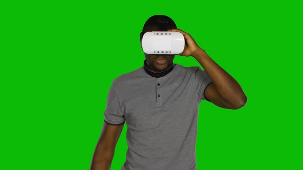Man Wanders Around the Room and Keeps the VR Mask By Hands. Green Screen alt