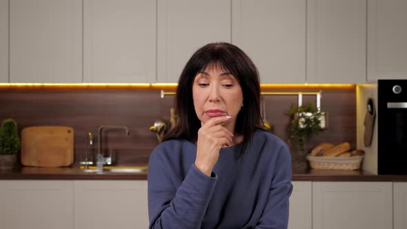 Thoughtful Aged Woman Listens Online Remote Video Conference Call Webcam Laptop alt