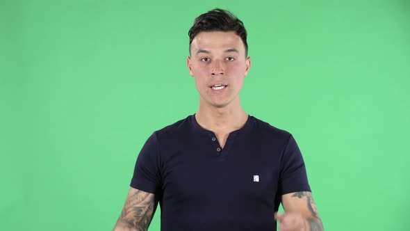 Portrait of a Handsome Young Guy Looking Straight Is Upset and Waving Her Hands in Indignation alt