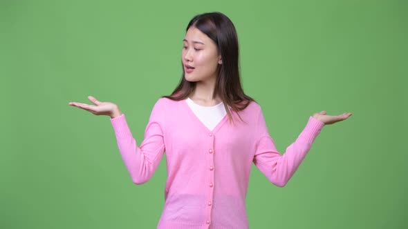 Young Beautiful Asian Woman Choosing Between Left and Right