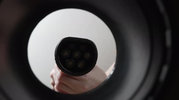 Plugging in an Electric Car at Outlet Socket alt