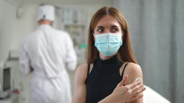 Positive Young Woman Gesturing Thumb Up After Vaccination in Clinic Indoors alt