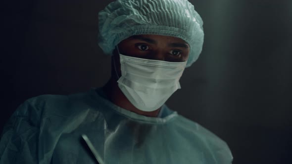 Confident Surgeon Operating Patient in Dark Hospital Emergency Ward Portrait alt