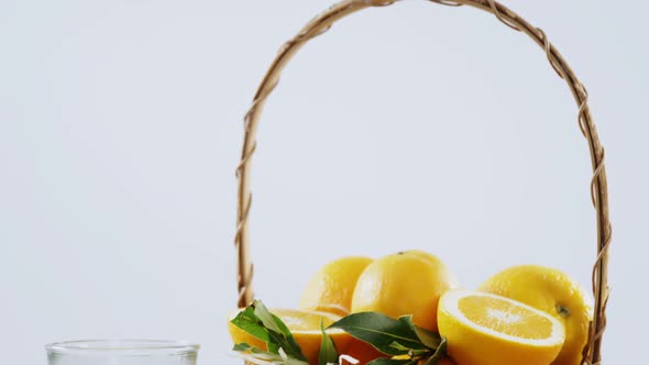 Close-up of sweet limes in wicker basket and glass of juice alt