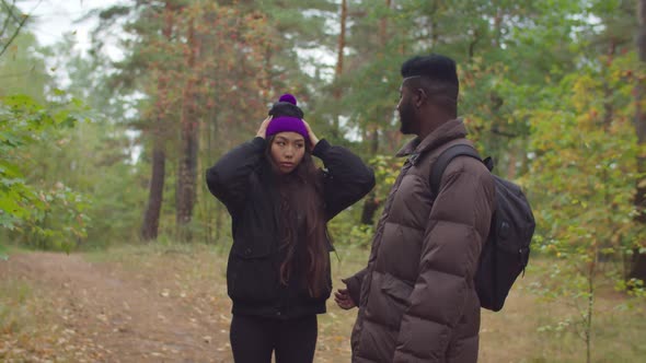 African Traveler Encouraging Tired Woman on Hike alt