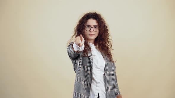 Serious Young Woman Pointing to the Lost Gesture and Pointing to the Room with a Sarcastic Smile on alt