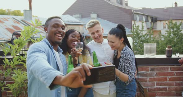 Mixed Race Friends Making Selfie During Meeting in Somebody's Home on Terrace at Summertime alt