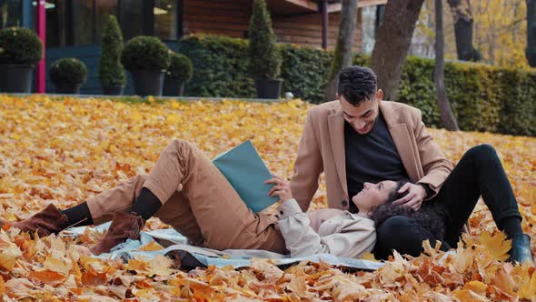 Happy Couple in Love Enthusiastically Reading Book in Autumn Park Young Spanish Man and Attractive alt
