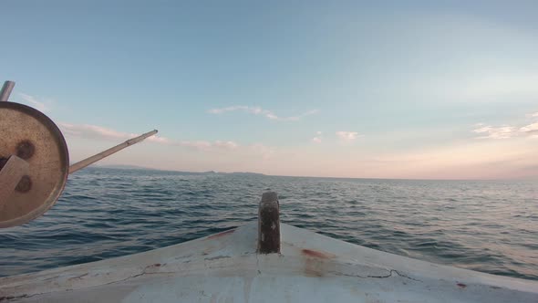 Point of view from inside of a sailing fishing boat. Sailing forward into the sunset. Calm water out alt
