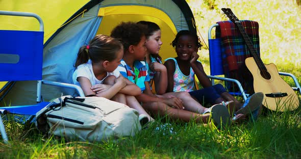 Kids interacting with each other outside tent at campsite alt