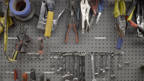 Hand tools hang on a workshop wall alt