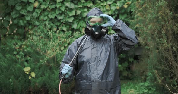 Man in Chemical Protection Suit is Using Pulivelizer to Spraying Chemical Mix