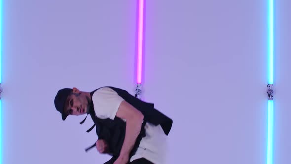Professional Hip Hop Dancer Practicing Street Dance Elements Against Bright Neon Lights in Studio alt